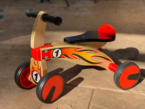 Ride on four wheeled wooden push bike on rubber wheels for toddlers.